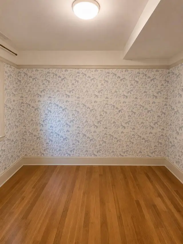 Blue animal-print wallpaper in a child's room with wood floor, Vancouver